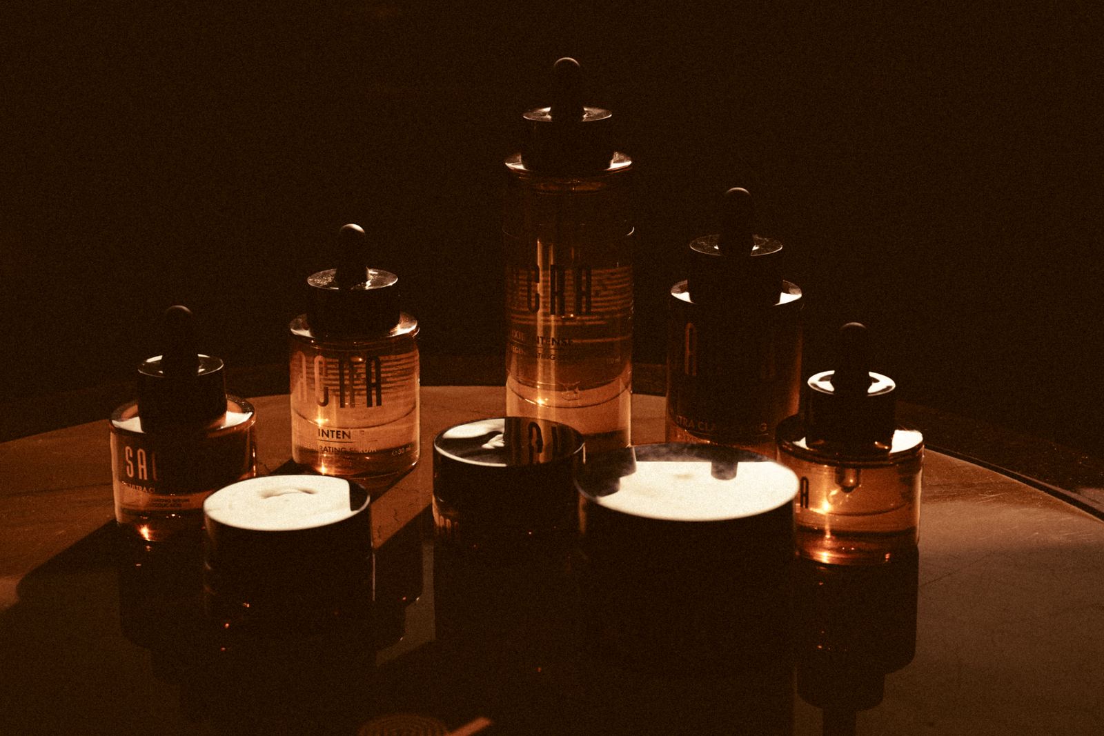The SACRA collection on a dark table in low golden light