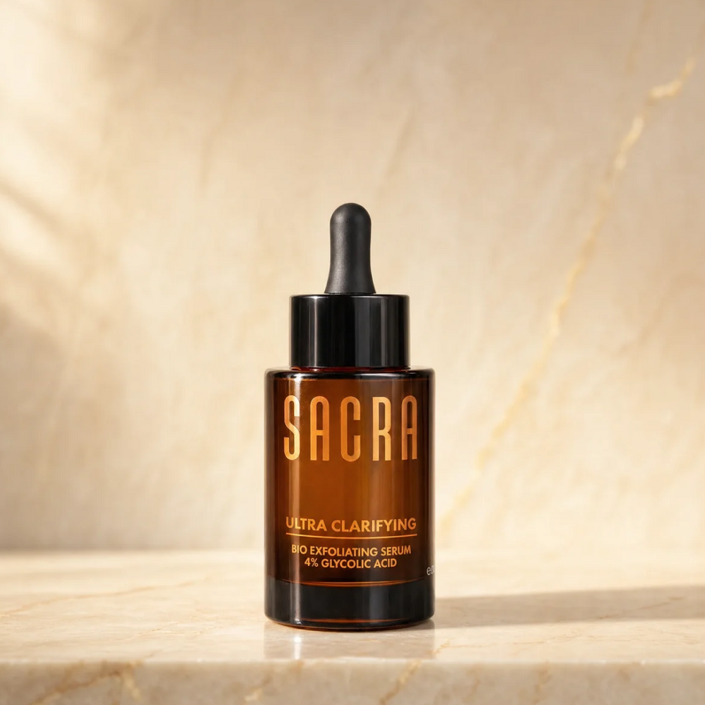 SACRA Ultra Clarifying Bio Exfoliating Serum 4% Glycolic Acid, amber glass dropper bottle on marble