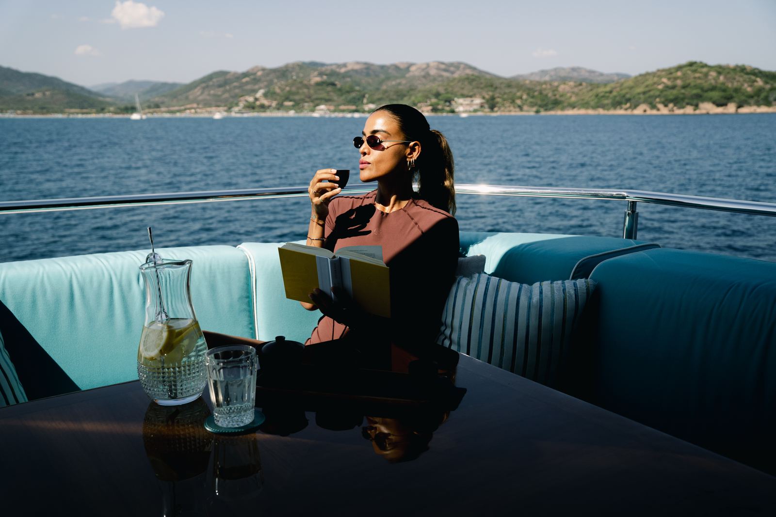 A woman on a boat with a tea tray and the SACRA box